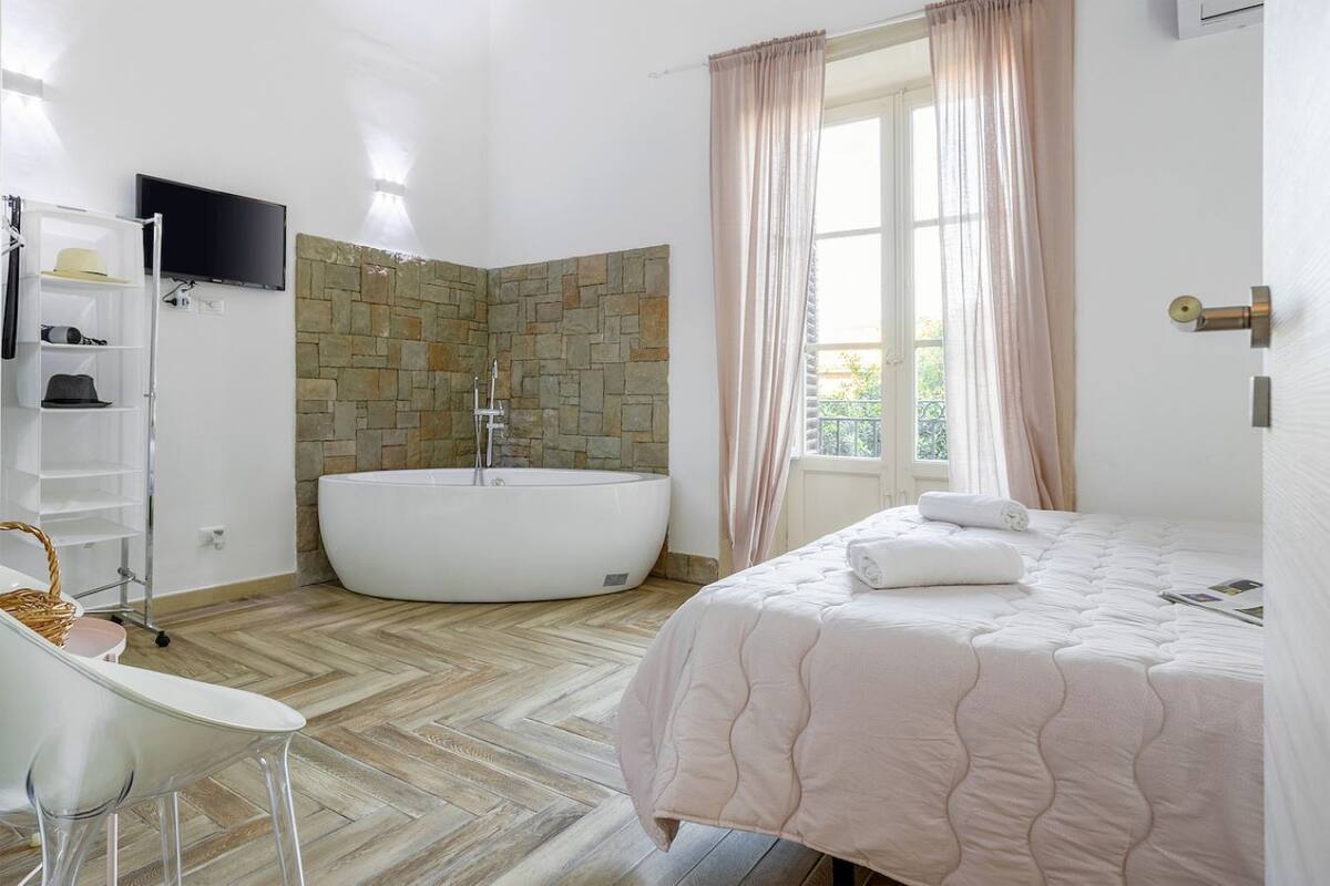 A modern bathroom with a freestanding bathtub, a white sink, and a vanity.