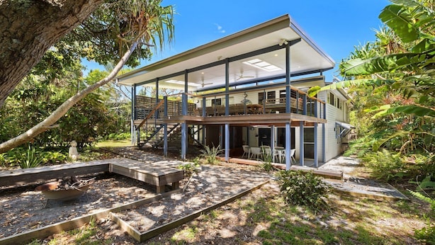 A two-story house with a covered patio and a deck.