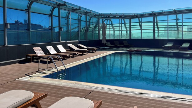 A rooftop pool area with sun loungers and a clear view of the city skyline. - Akmerkez Residence (Istanbul)