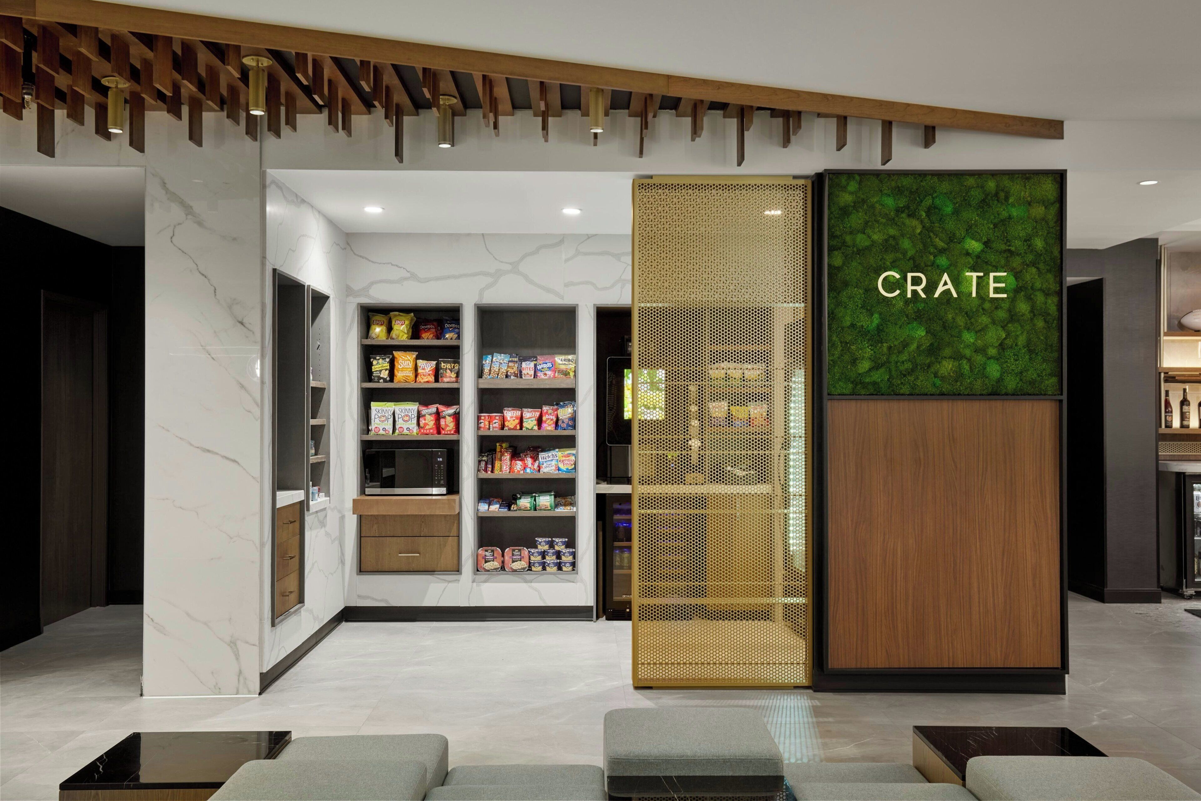 A modern interior with a marble wall, a section labeled "CRATE," and a variety of packaged goods on shelves.