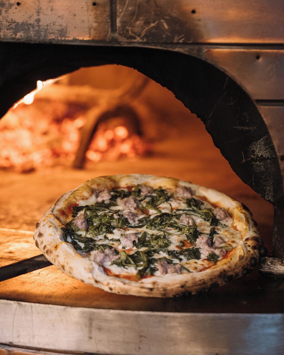 A pizza inside a brick oven.