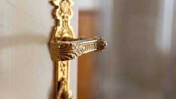 A close-up of a gold-colored door handle with intricate designs.