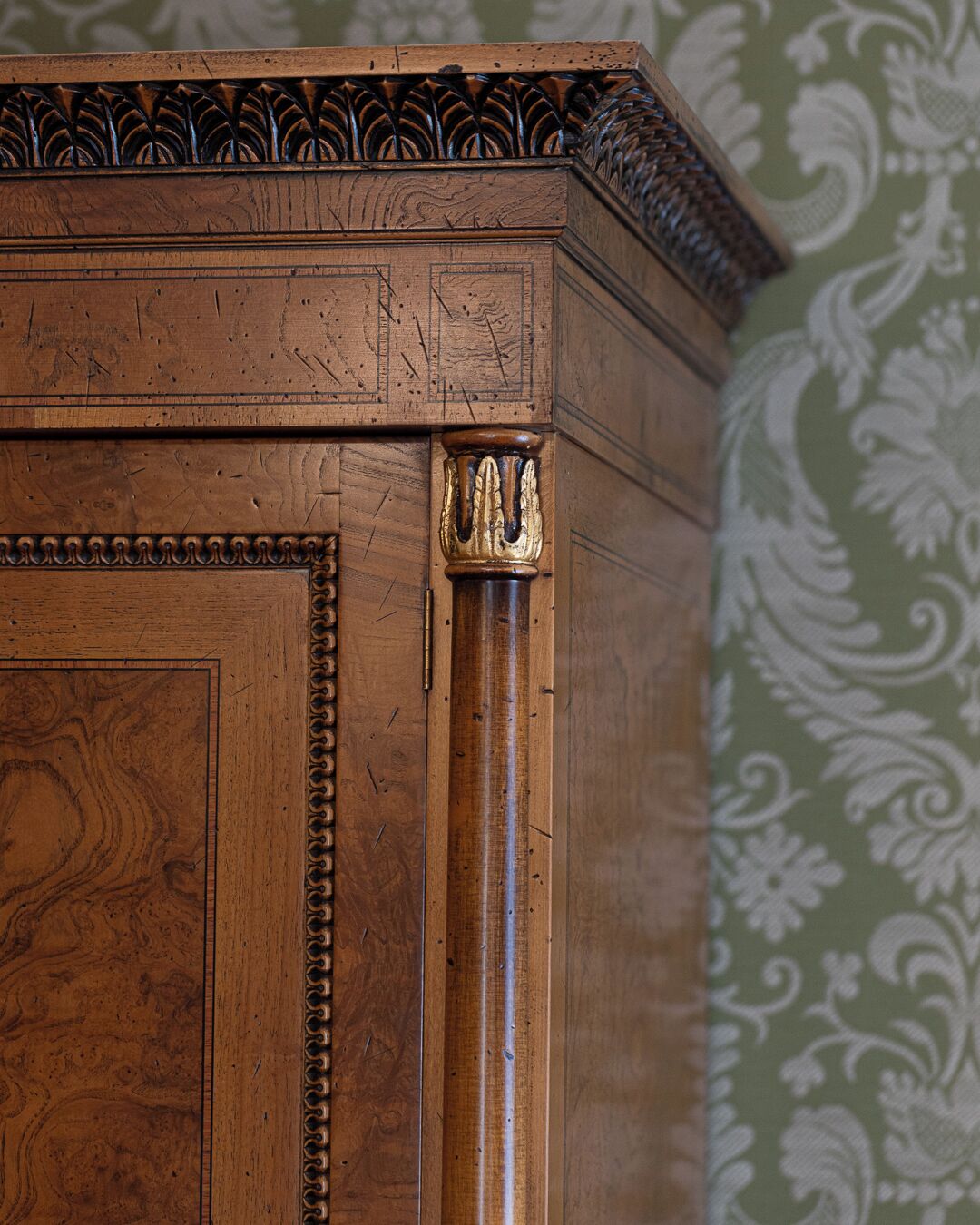 A wooden cabinet with intricate carvings and a decorative top.
