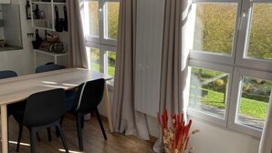 Une cuisine moderne avec un plan de travail en bois, des chaises noires et une table à manger.