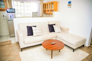 Appartement classique, balcon, vue sur la ville | Aire de séjour | Téléviseur connecté de 24 po avec télévision numérique