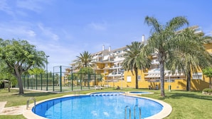 A swimming pool with a surrounding grassy area and palm trees. - Denia Dream II by Interhome (Dénia)
