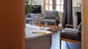 A living room with a sofa, a television, and a fireplace. - Luxury chalet apartment with ski-in/ski-out pool (Les Belleville)