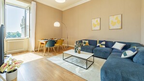 Un salon comprenant un canapé, une table basse et un coin repas avec des chaises et une table.
