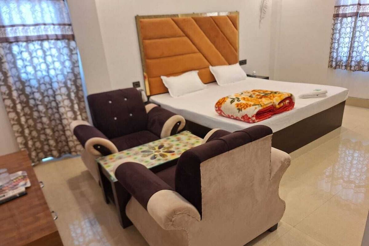 Hotellihuone, jossa on sänky, sohva ja pieni pöytä.