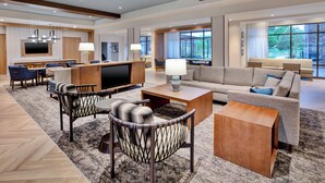 A spacious living area with a large flat-screen TV, comfortable seating, and a fireplace. - Staybridge Suites Grand Rapids South by IHG (Grand Rapids)