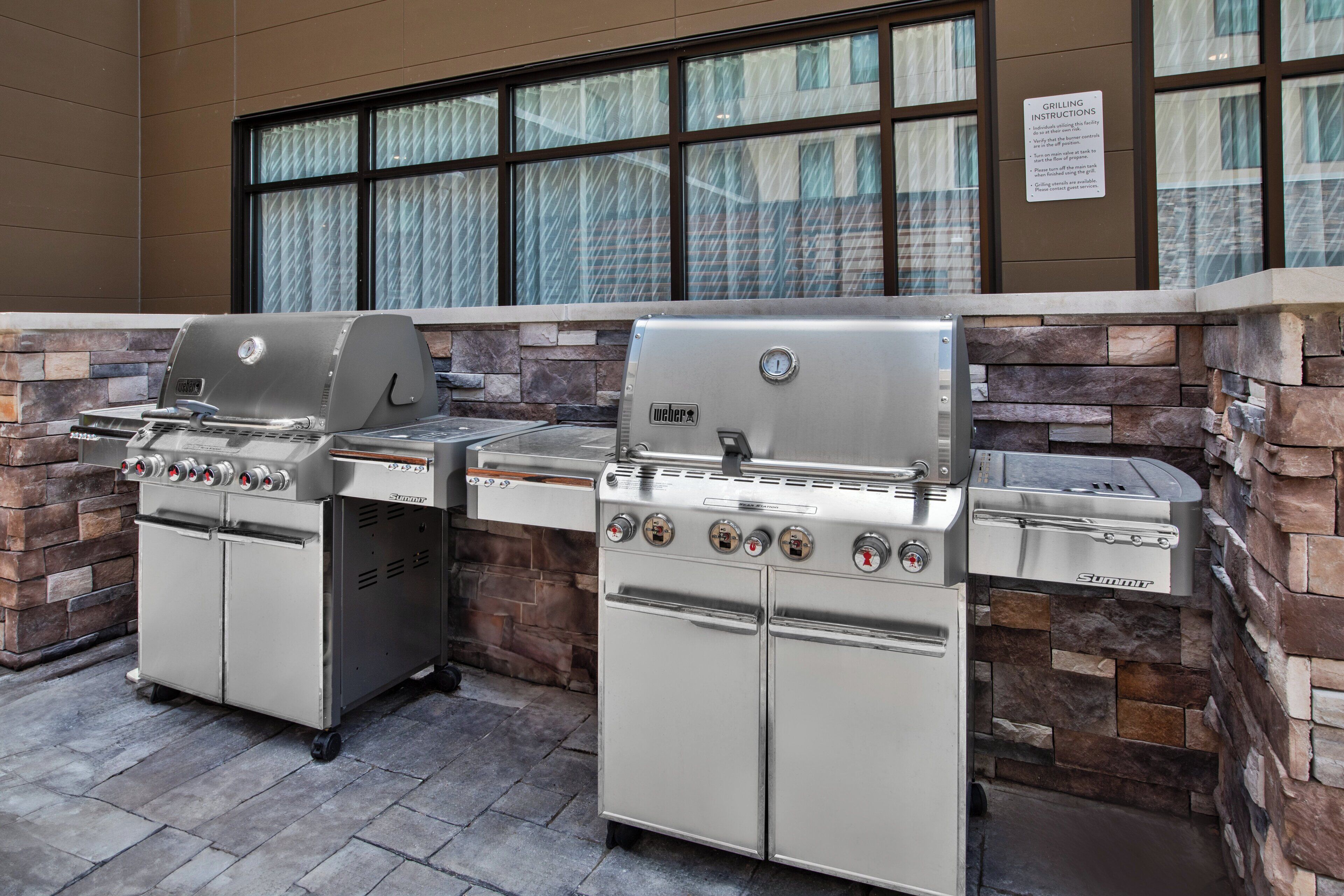A Weber grill station with a stone facade and large windows.