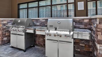 A Weber grill station with a stone facade and large windows.