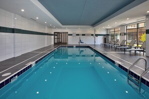 A swimming pool with clear blue water, tiled walls, and a sunlit area with lounge chairs. - Staybridge Suites Grand Rapids South by IHG (Grand Rapids)