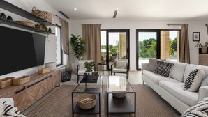 A modern living room with a sofa, coffee table, TV, and a view of the outdoors through large windows. - Villa with pool and wellness for 8 persons, 4 bedrooms,  (Poreč)