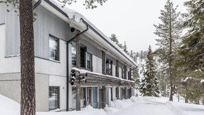 A two-story building with a log facade, large windows, and a snow-covered landscape. - Holiday Club Rukatunturi Apartments (Kuusamo)