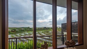 A view of terraced rice fields through large windows with a balcony railing. - Alsava Villa and Suites (Canggu)