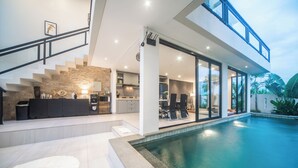 A modern house with a swimming pool, a kitchen, and a dining area. - Alsava Villa and Suites (Canggu)