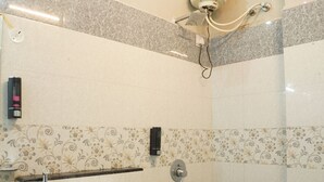 Et badeværelse med toilet, håndtørrer og bruser.