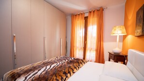 Ein Hotelzimmer mit Bett, Nachttisch, Lampe und Kleiderschrank.