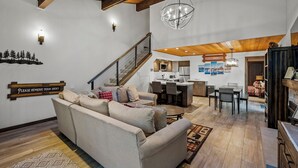 A spacious living area with a sofa, a staircase, a kitchen, and a dining area. - 32 Forest Pines | 3BR/2BA Incline Village, Pool (Incline Village)
