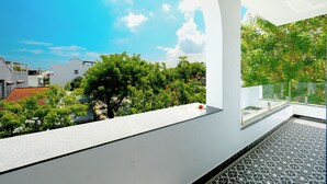 Un balcón moderno con una vista despejada del cielo y follaje circundante.