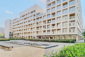 Un edificio de varios pisos con balcones, un patio interior y una fuente.