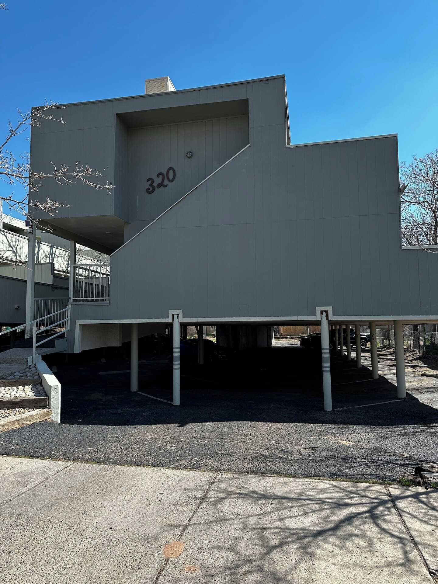 A modern building with a flat roof and a large number '320' on its side.