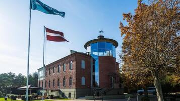 A building with a brick facade, a glass tower, and a flagpole with flags.