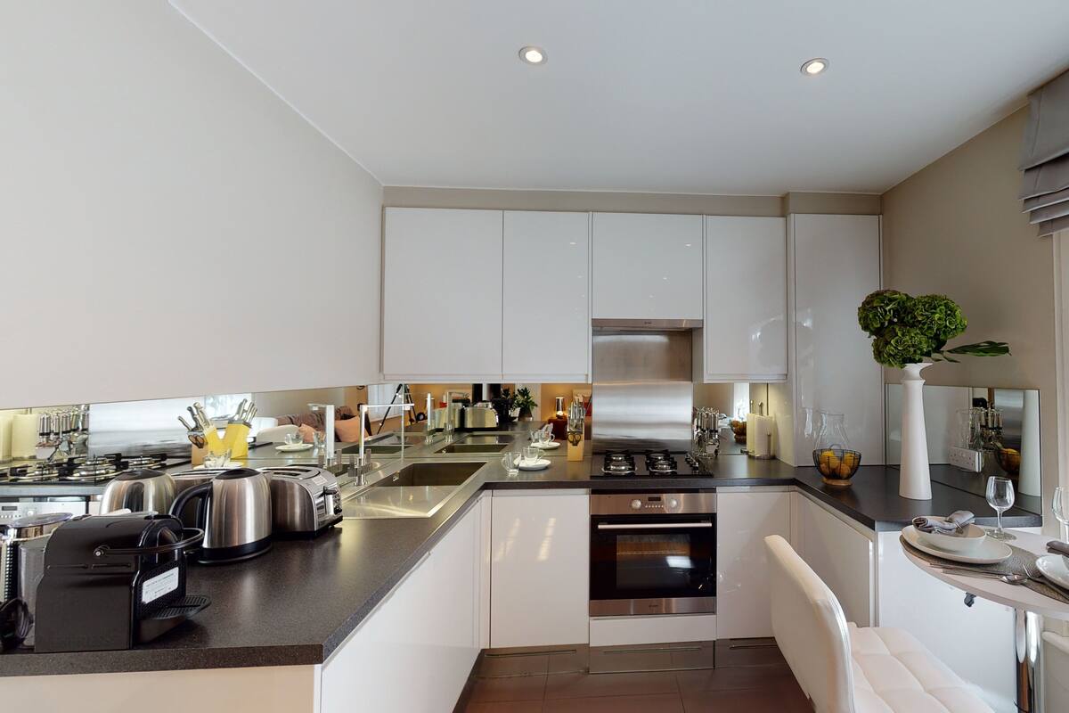 A modern kitchen with white cabinets, stainless steel appliances, and a central island with seating.