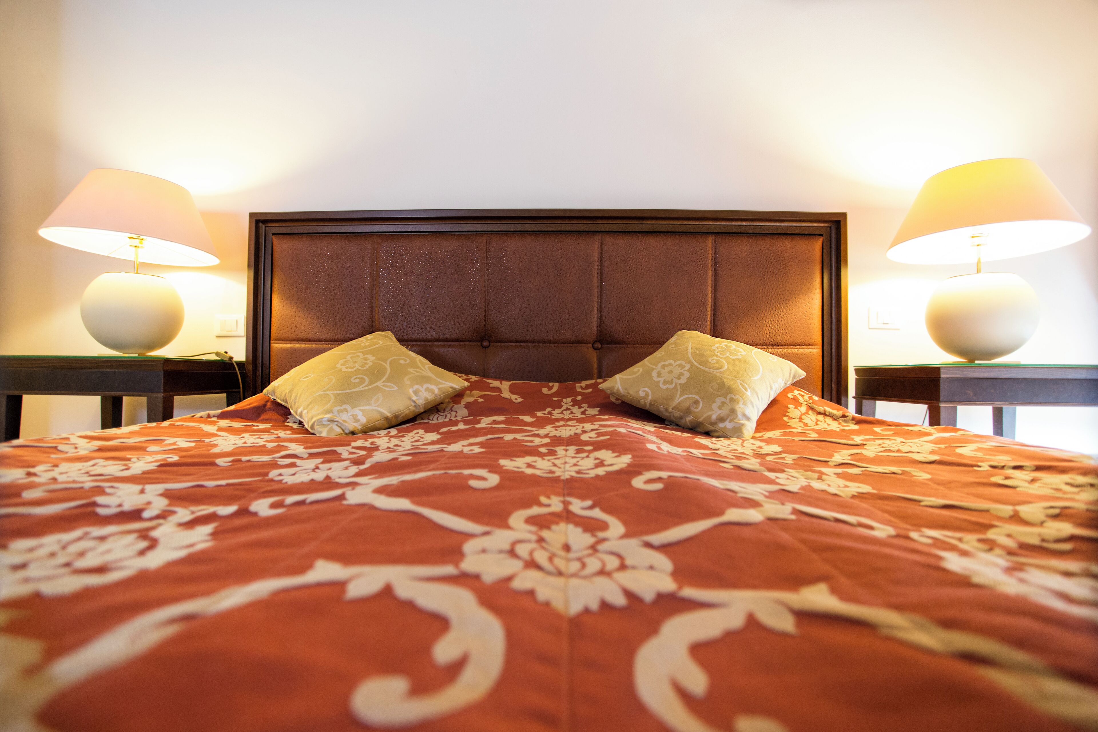 Una habitaci ón de hotel con una cama grande, dos mesitas de noche y dos lámparas.