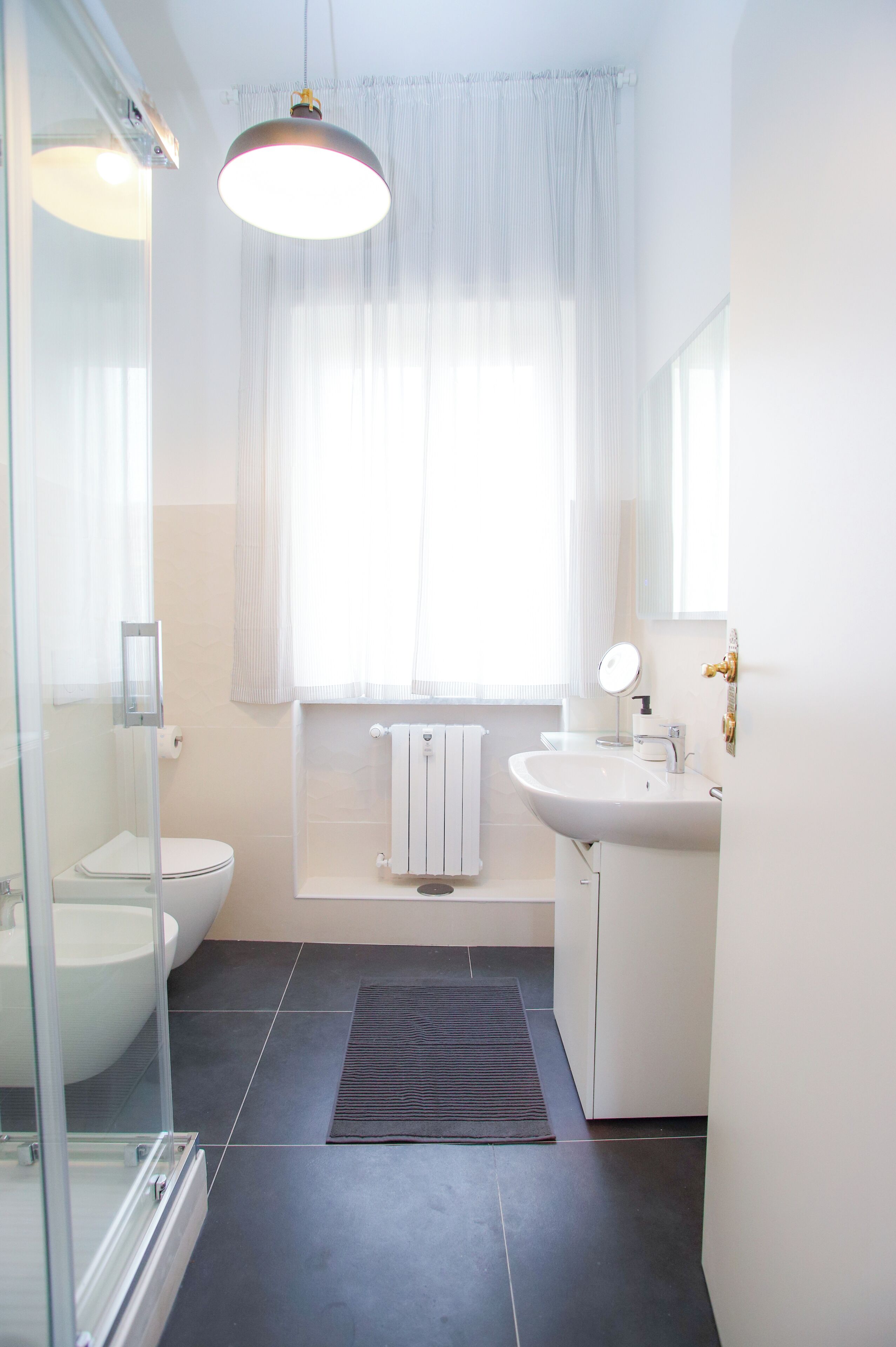 Un bagno moderno con WC, lavabo e doccia.