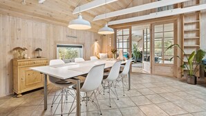 A spacious dining area with a long table and chairs, wooden walls, and large windows. - Cozy home in Spøttrup with WiFi (Spøttrup)