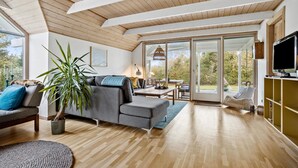 A spacious living room with a grey sofa, a large potted plant, and a wooden ceiling. - Cozy home in Spøttrup with WiFi (Spøttrup)