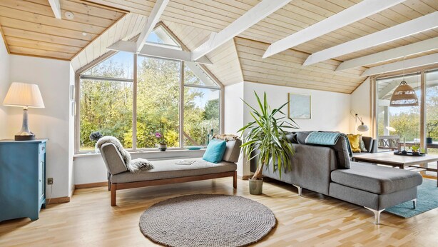A spacious living room with a high ceiling, large windows, a sofa, a table, and a lamp. - Cozy home in Spøttrup with WiFi (Spøttrup)