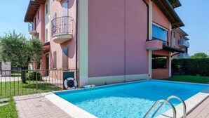 A swimming pool adjacent to a multi-story building with balconies. - Adele's House - with pool terrace and WiFi (Sirmione)