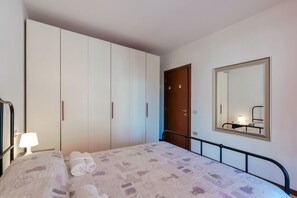 A bedroom with a bed, a wardrobe, a mirror, and a door. - Adele's House - with pool terrace and WiFi (Sirmione)