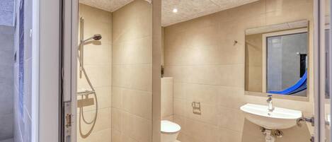 Un baño moderno con ducha, inodoro y lavabo.
