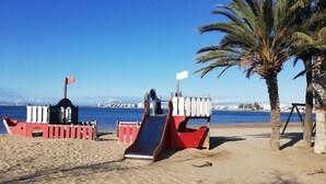Una platja amb un tobogan i una estructura petita amb forma de vaixell.