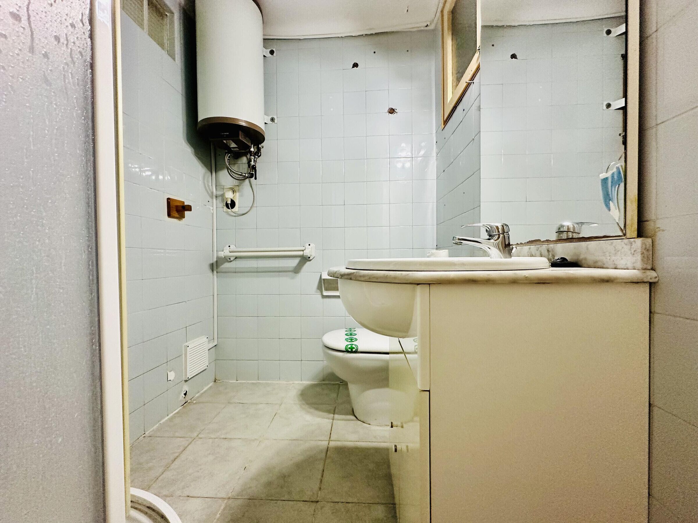 A bathroom with a toilet, sink, and shower.