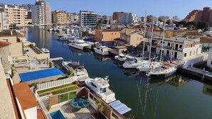 A marina with boats docked, a swimming pool, and residential buildings in the background.