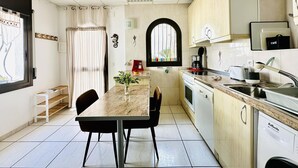 A compact kitchen with a dining area, featuring a marble countertop, a coffee maker, and a sink. - Charming House Near Natural Park - Hiking, Biking, Windsurfing & Communal Pool (Roses)