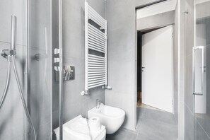 Een douche, een haardroger, een bidet, handdoeken