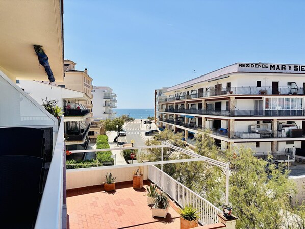 A multi-story building with balconies, a clear view of the sea, and a sign reading 'RESIDENCE MAR Y SIE.'