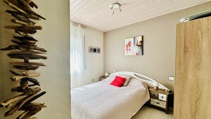 A bedroom with a bed, a bedside table, a nightstand, a wall-mounted artwork, and a ceiling light. - Bright apartment with sea view, pets allowed (Roses)