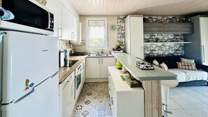 A compact kitchen with a Hisense refrigerator, a microwave, a sink, and a small window. - Bright apartment with sea view, pets allowed (Roses)