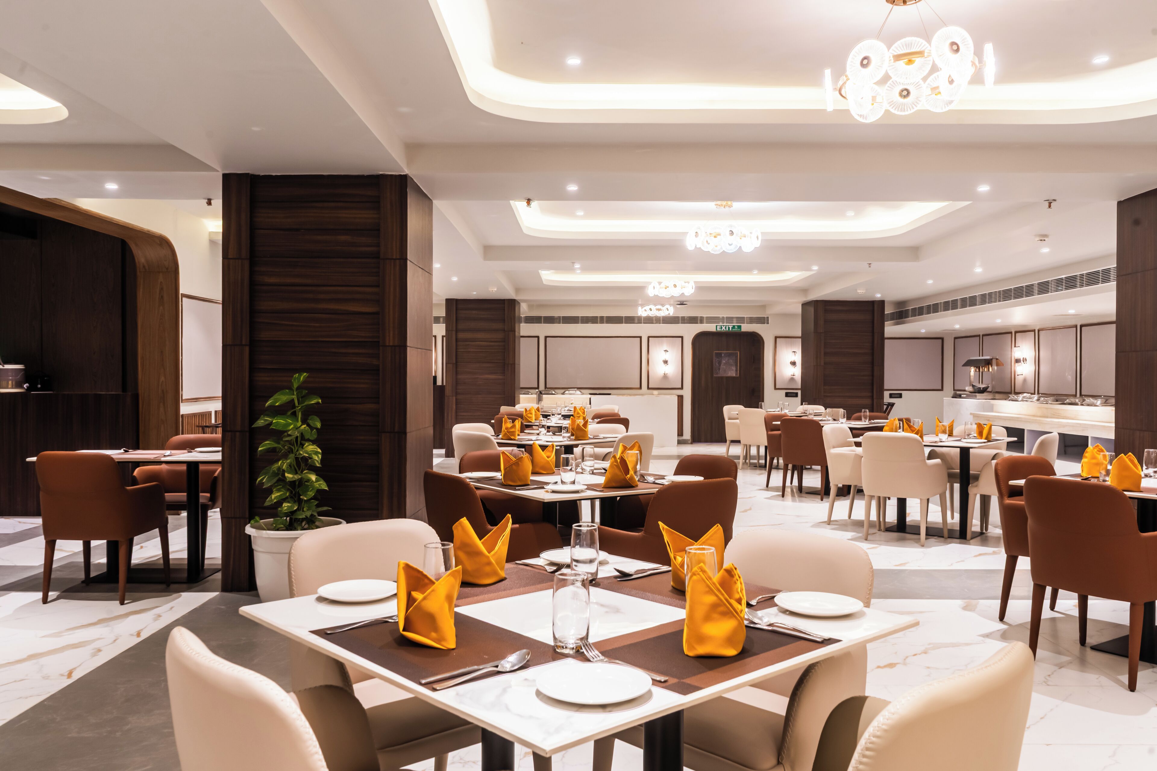 Un espace de restauration moderne, doté de plusieurs tables dressées pour accueillir les clients, et caractérisé par un design épuré et contemporain, ainsi qu’une palette de couleurs neutres.