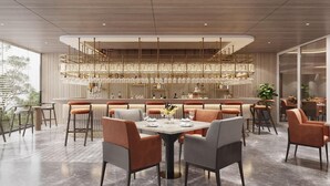 Un espace de restauration moderne doté d’un bar central, de plusieurs options d’aménagement et d’un lustre décoratif.