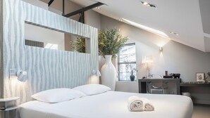 Een moderne hotelkamer met een groot bed, nachtkastjes, een bureau en een spiegel.