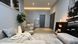 A modern living room with a sofa, a coffee table, a potted plant, and a fireplace. - Enjoy an elegant apartment with air conditioning, fast Wi-Fi, heated floors, and convenient parking—just a 5-minute walk from the Jan Cunen Museum. (Oss)