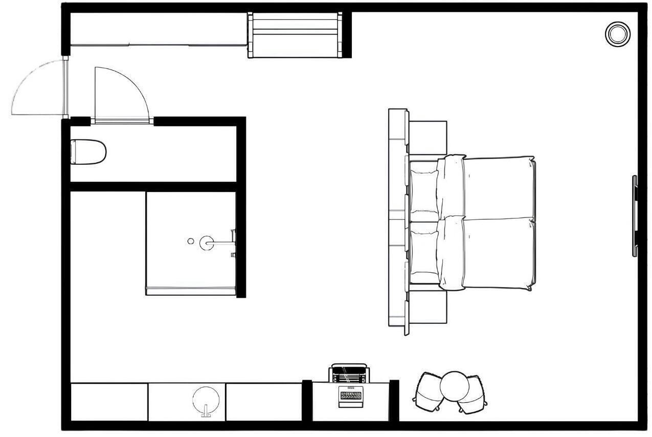 Een plattegrond van een hotelkamer met een bed, een bureau, een stoel, een klein tafeltje en een wastafel.